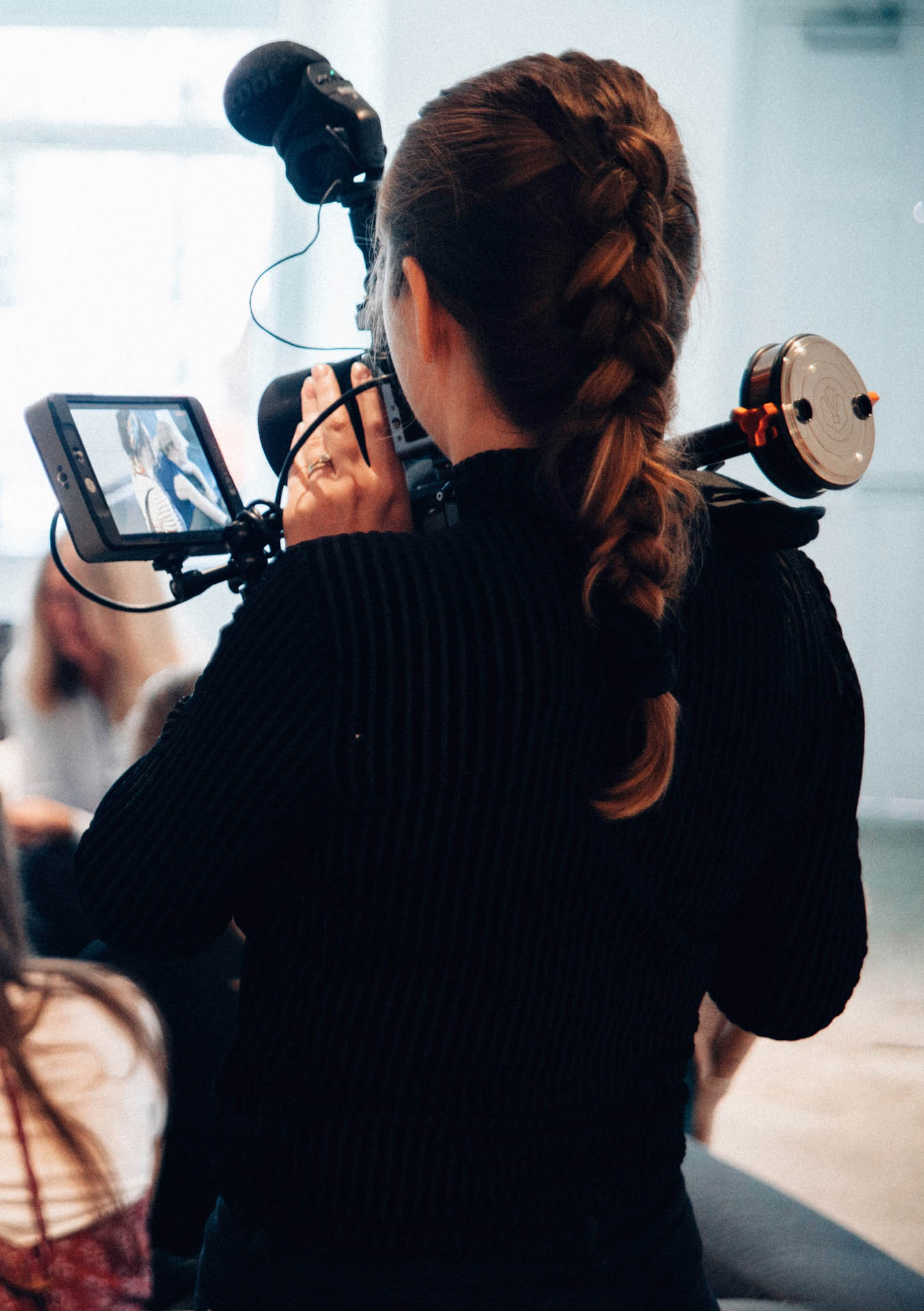 young lady with video camera filming meeting