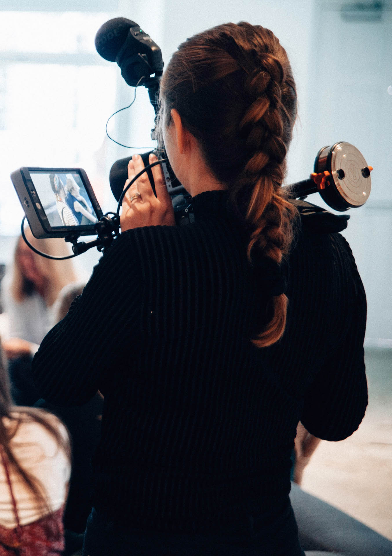 Young lady with video camera filming meeting